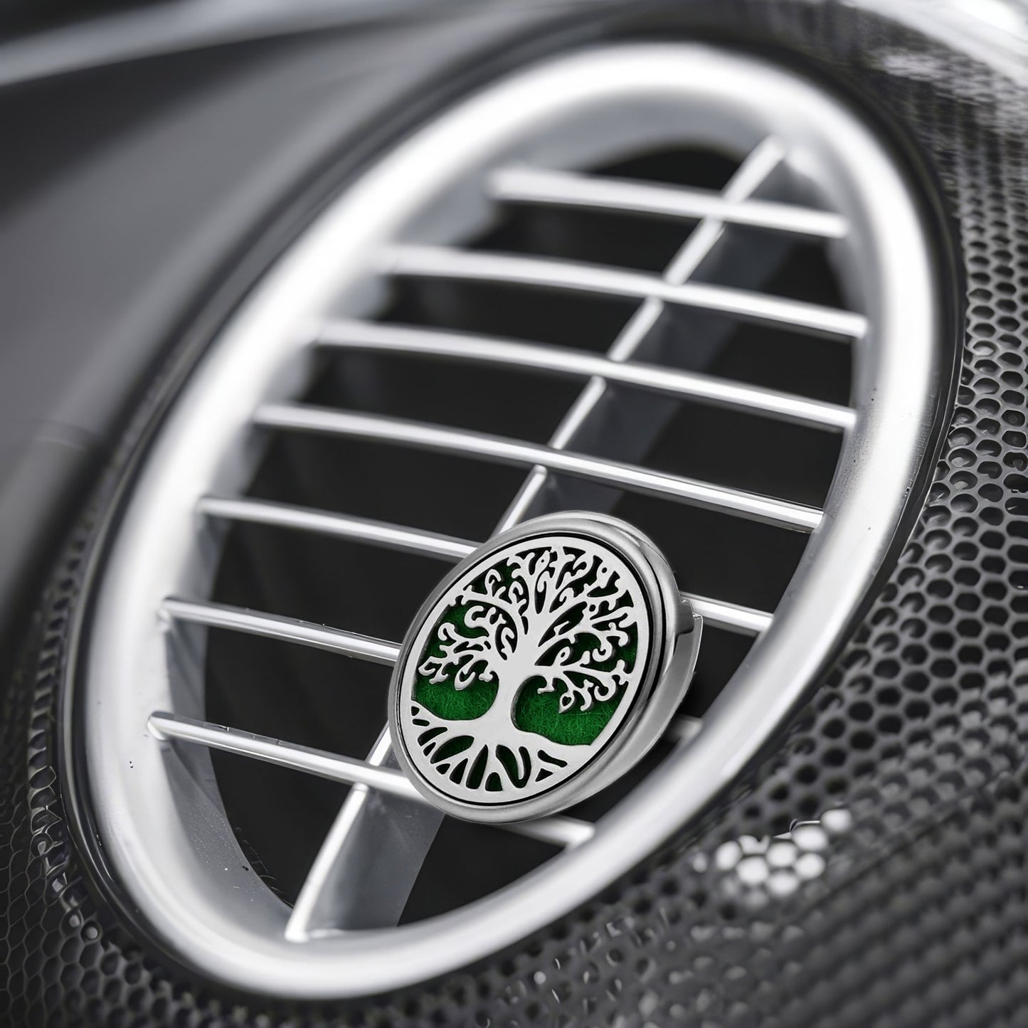 Close-up of a car air fan with a distinctive air freshener featuring a tree design.