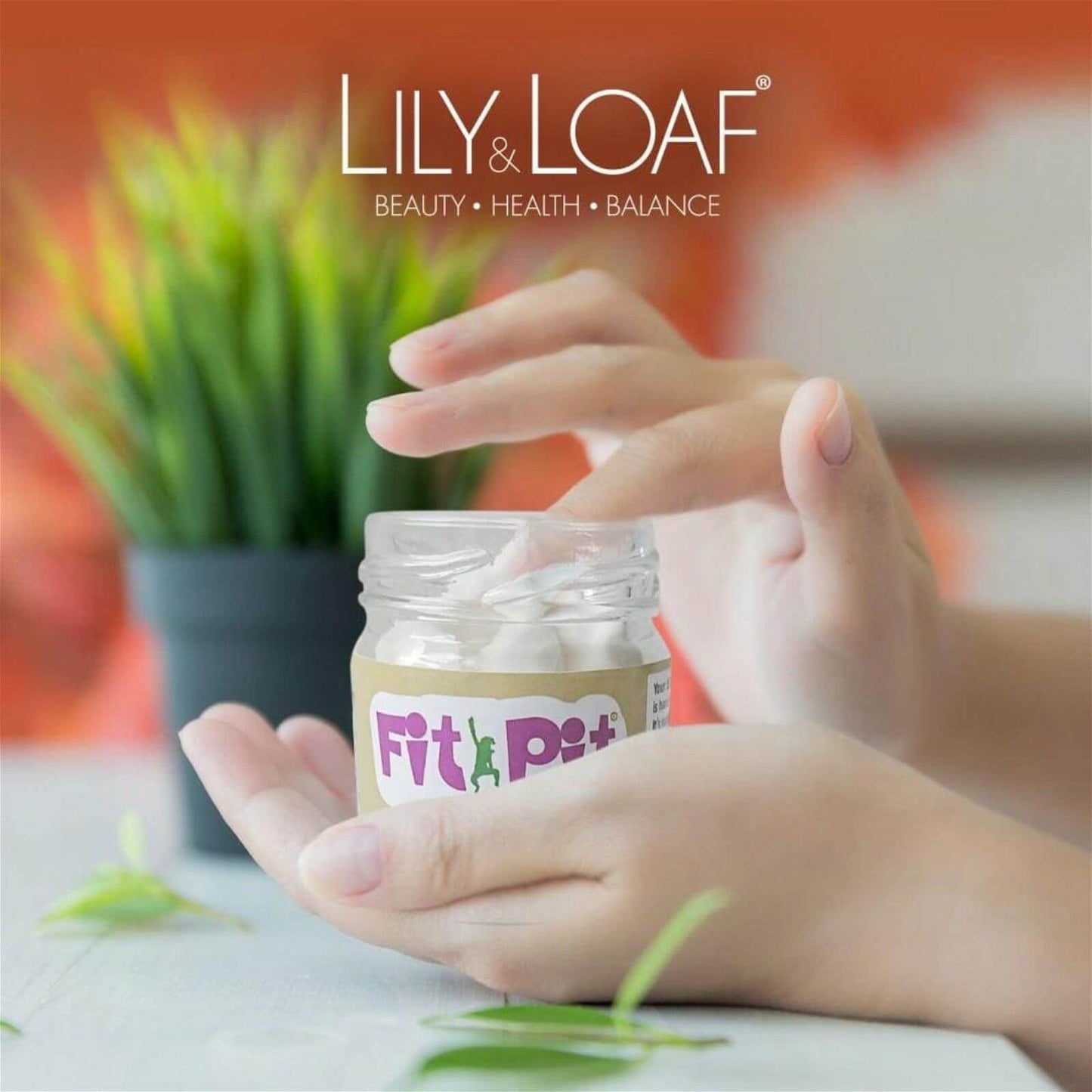 A glass jar of Fit Pit deodorant being held to show the consistency of the product