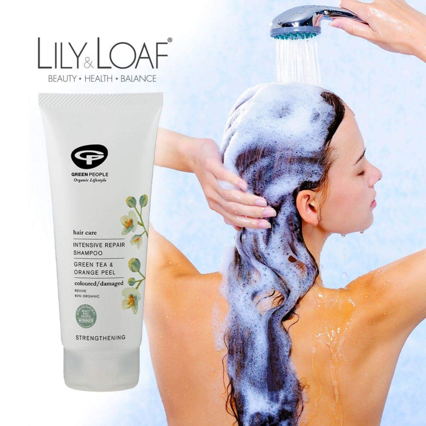 A woman shampooing her hair with Green People Intensive Repair Shampoo in the foreground