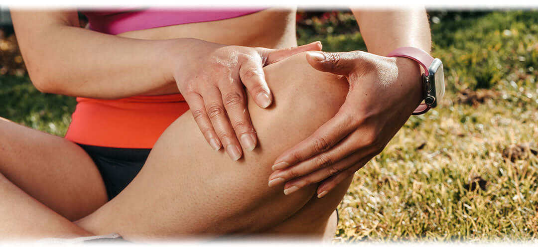 A person holding their knee in discomfort, indicating joint pain.