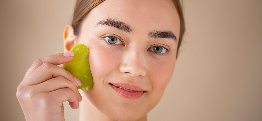 portrait-beautiful-woman-with-clear-skin-using-guasha-massage-her-face