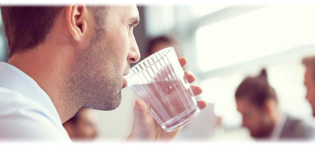 A person holding a glass of water, representing the importance of hydration.