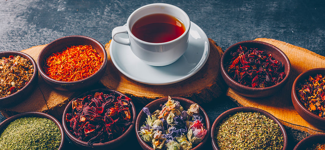 tea-herbs-bowls-with-wood-stubs-cup-tea-high-angle-view-dark-textured-background