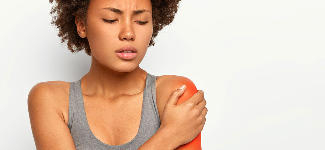 dissatisfied-afro-woman-touches-red-shoulder-stretched-muscles-sport-training-has-sad-expression-wears-grey-bra