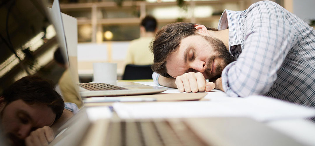 male asleep in the afternoon leaning on his desk
