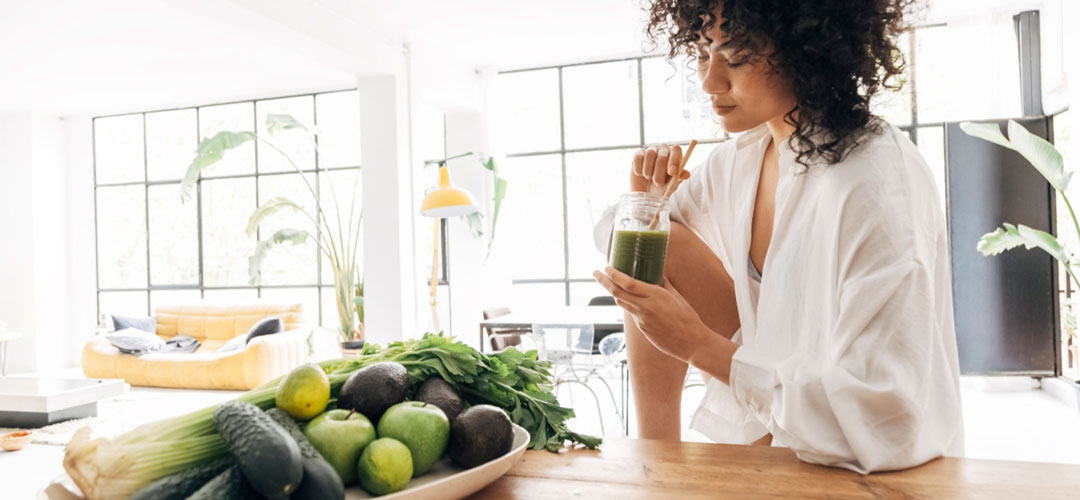 lady drinking a fresh glass of liquid chlorophyll in the kitchen