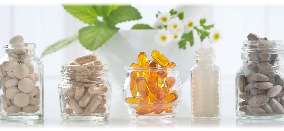 Glass containers filled with brightly coloured tablets and capsules