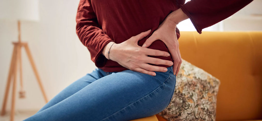 lady holding hips as she suffers the arthritis pain