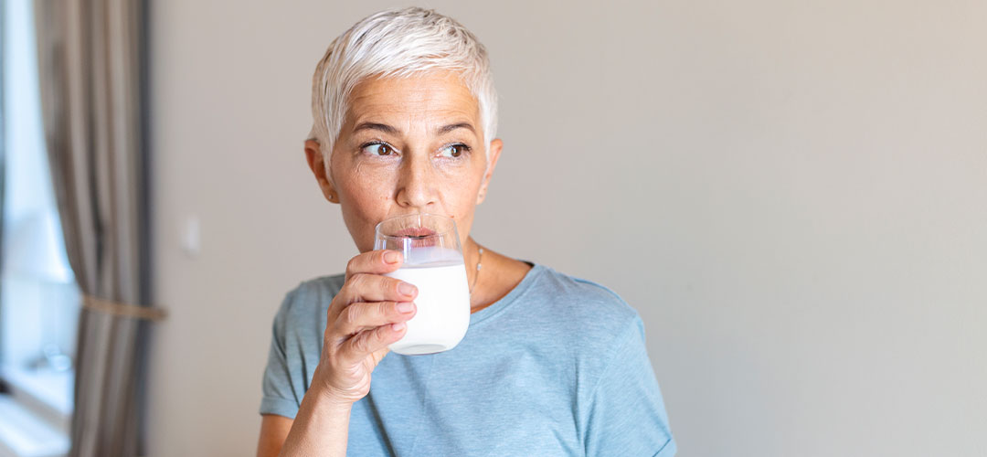 senior-woman-holding-glass-protein-home-middle-age-woman-drinking-glass-fresh-milk-with-happy-face-standing-smiling-with-confident-smile-showing-teeth