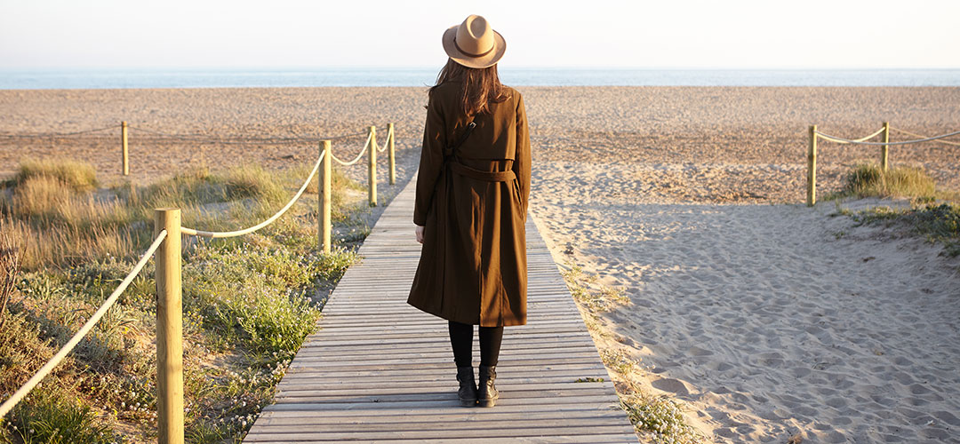 back-view-brunette-girl-hat-coat-standing-boardwalk-by-seaside