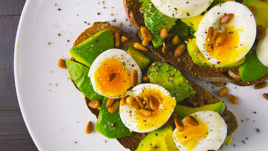 Soft-boiled eggs with avocado and spinach served in a healthy breakfast bowl.