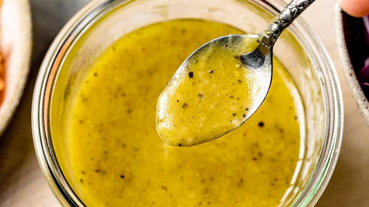 Homemade Dijon salad dressing in a bowl with herbs