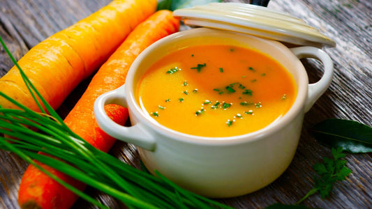 Creamy roasted carrot and cashew soup garnished with herbs and served warm
