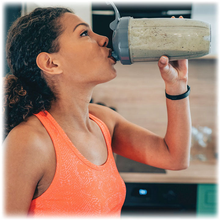 Woman drinking fibre based smoothie in a shaker
