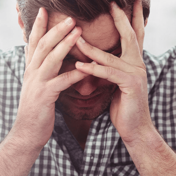 A man holding hi head in his hands stressed