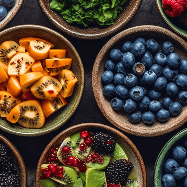 Wooden bowls filled with a variety of colourful fruits such as blueberries and kiwi