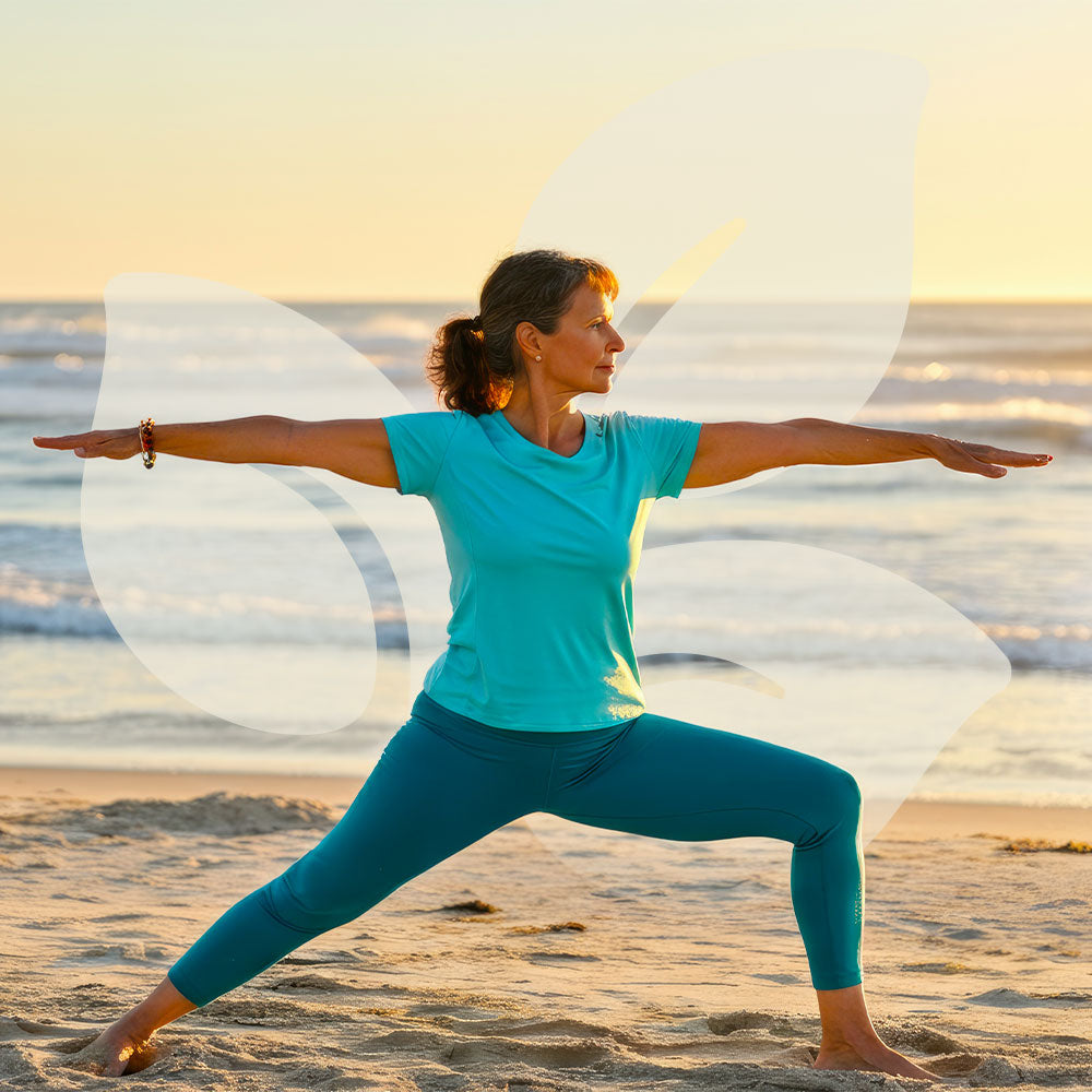 Woman practicing yoga on a beach with a sunset in the background