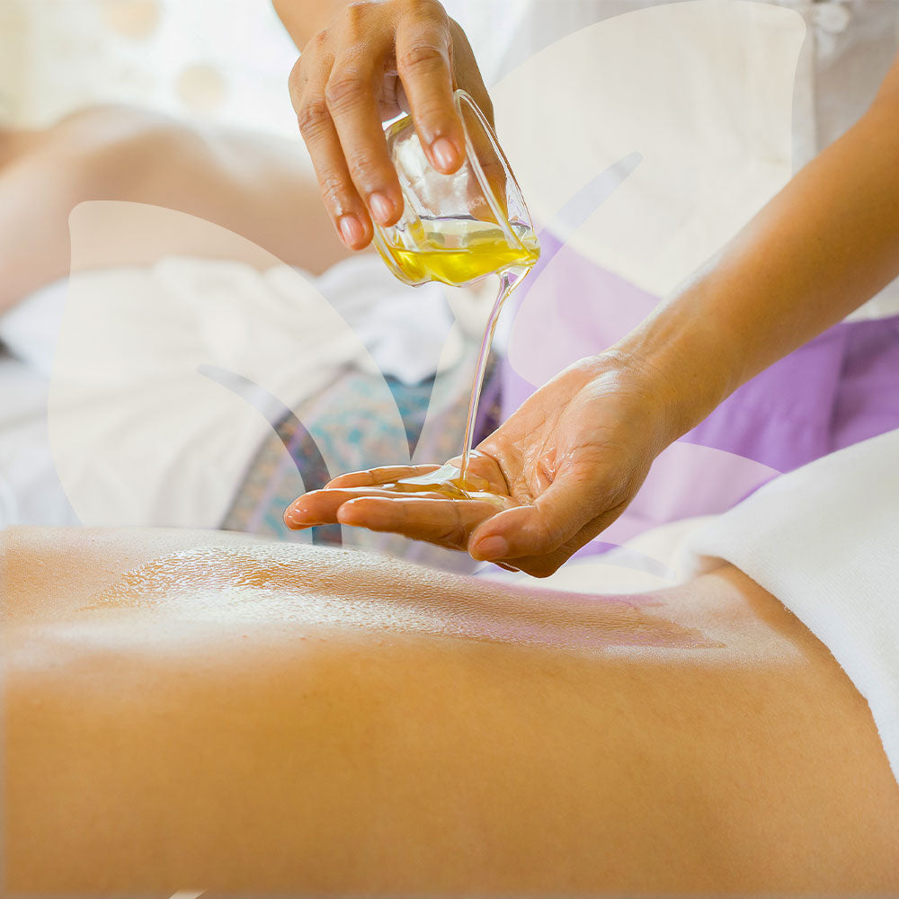 Person pouring oil onto a hand receiving a massage