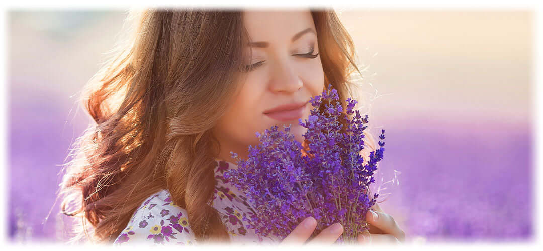 Woman inhales the natural fragrance of lavender, Lily & Loaf's essence for calm and relaxation.