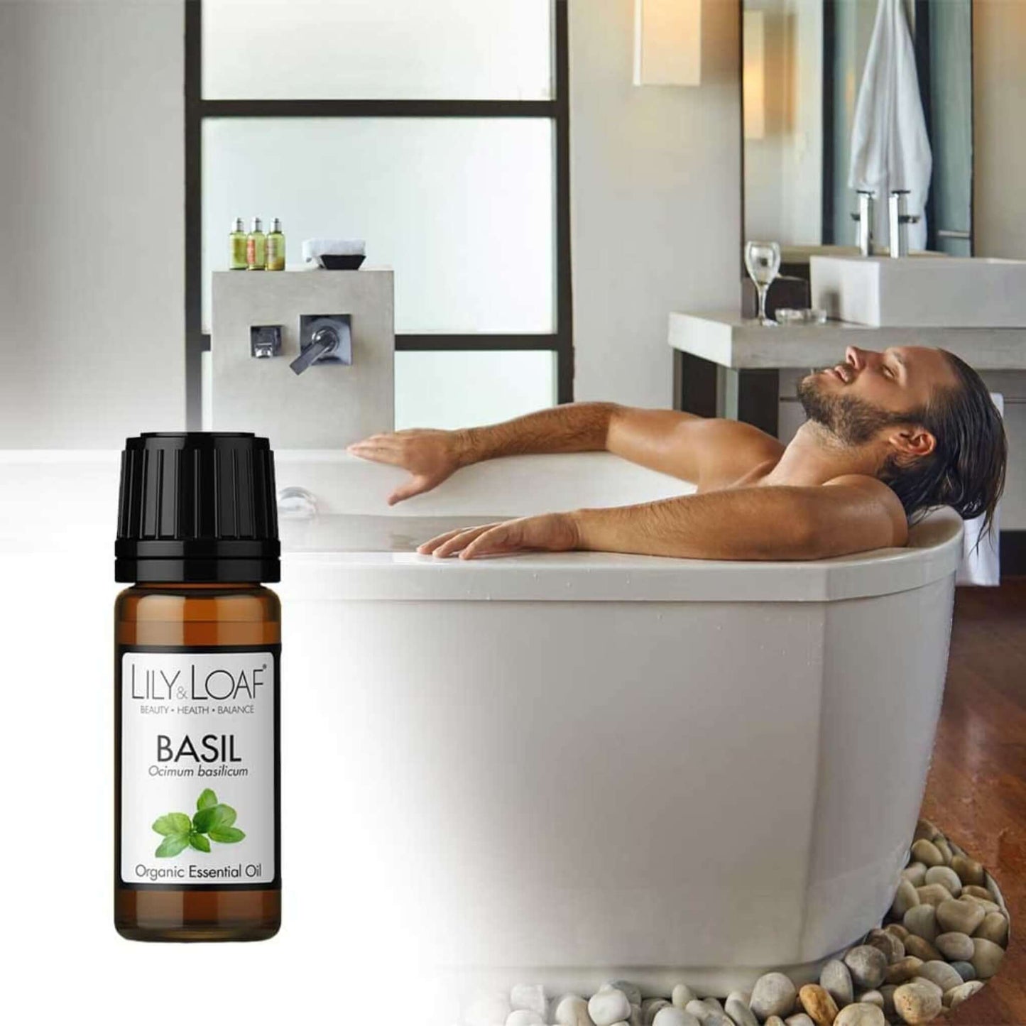 A man relaxing in the bath with a bottle of Basil Organic Essential Oil