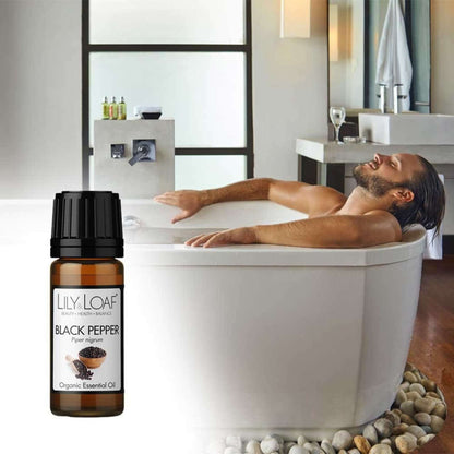 A man in a luxurious bath with a bottle of Lily & Loaf Black Pepper Organic Essential Oil in the forground