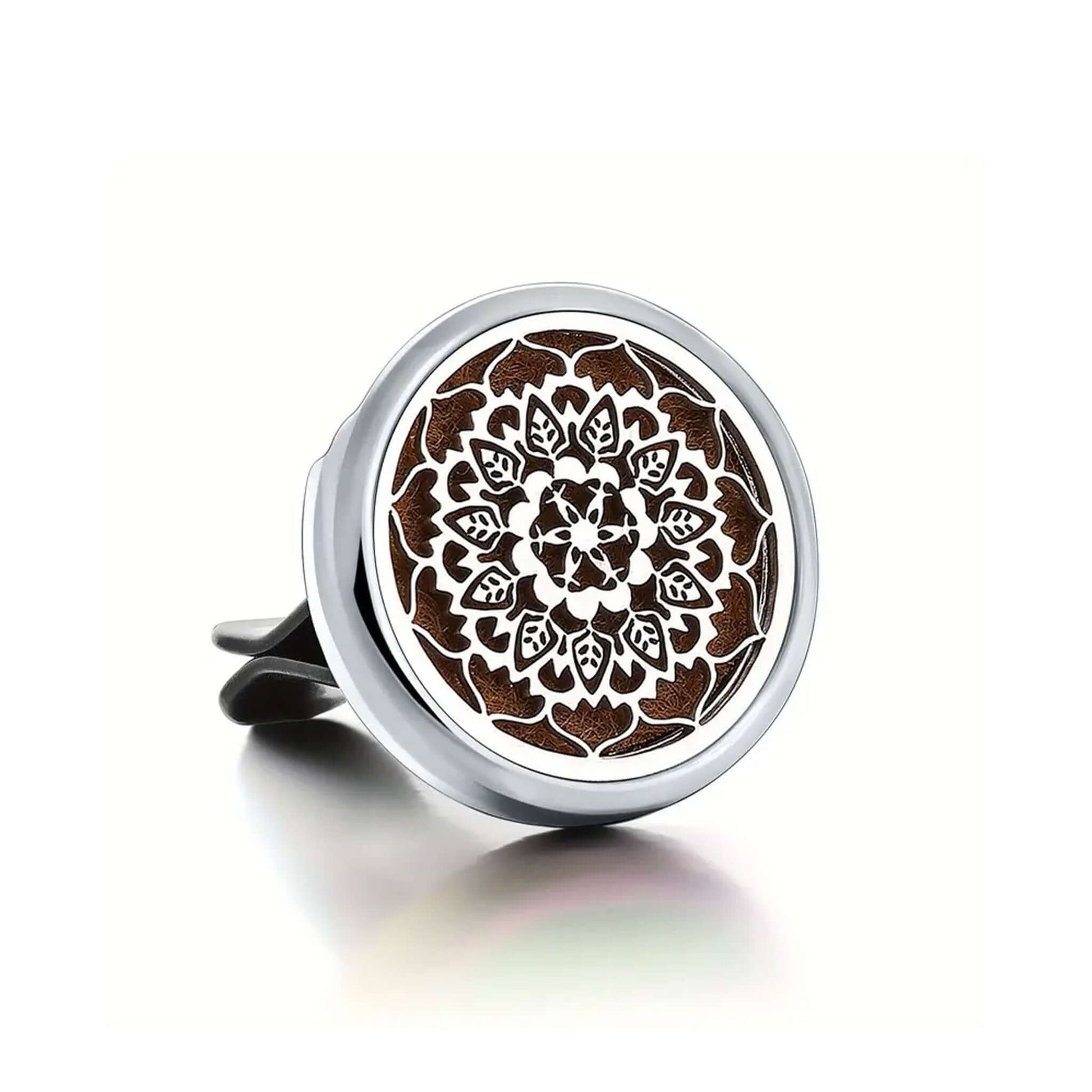 Round metal car air freshener with intricate design on a white background