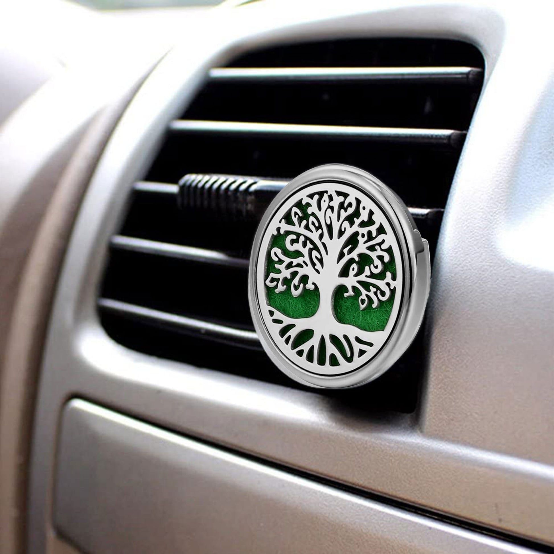 Close-up of a car air fan with a distinctive air freshener featuring a tree design.