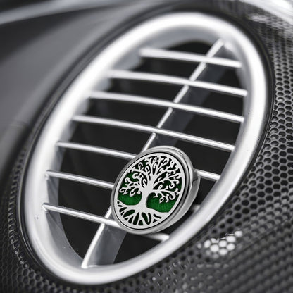 Close-up of a car air fan with a distinctive air freshener featuring a tree design.