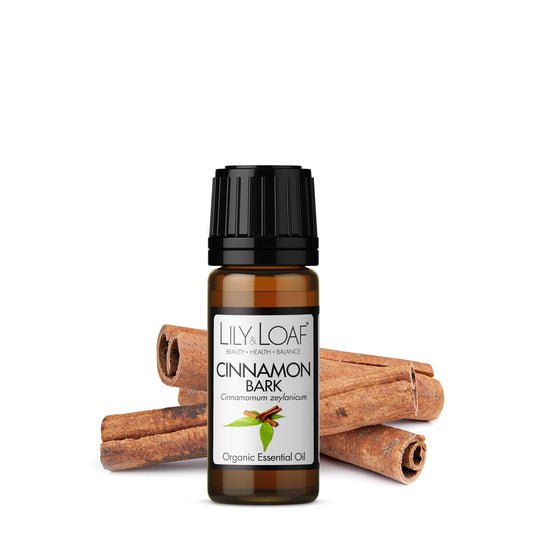 Cinnamon Leaf Organic Essential Oil surrounded by cinnamon sticks and leaves depicting the botanicals included in the oil