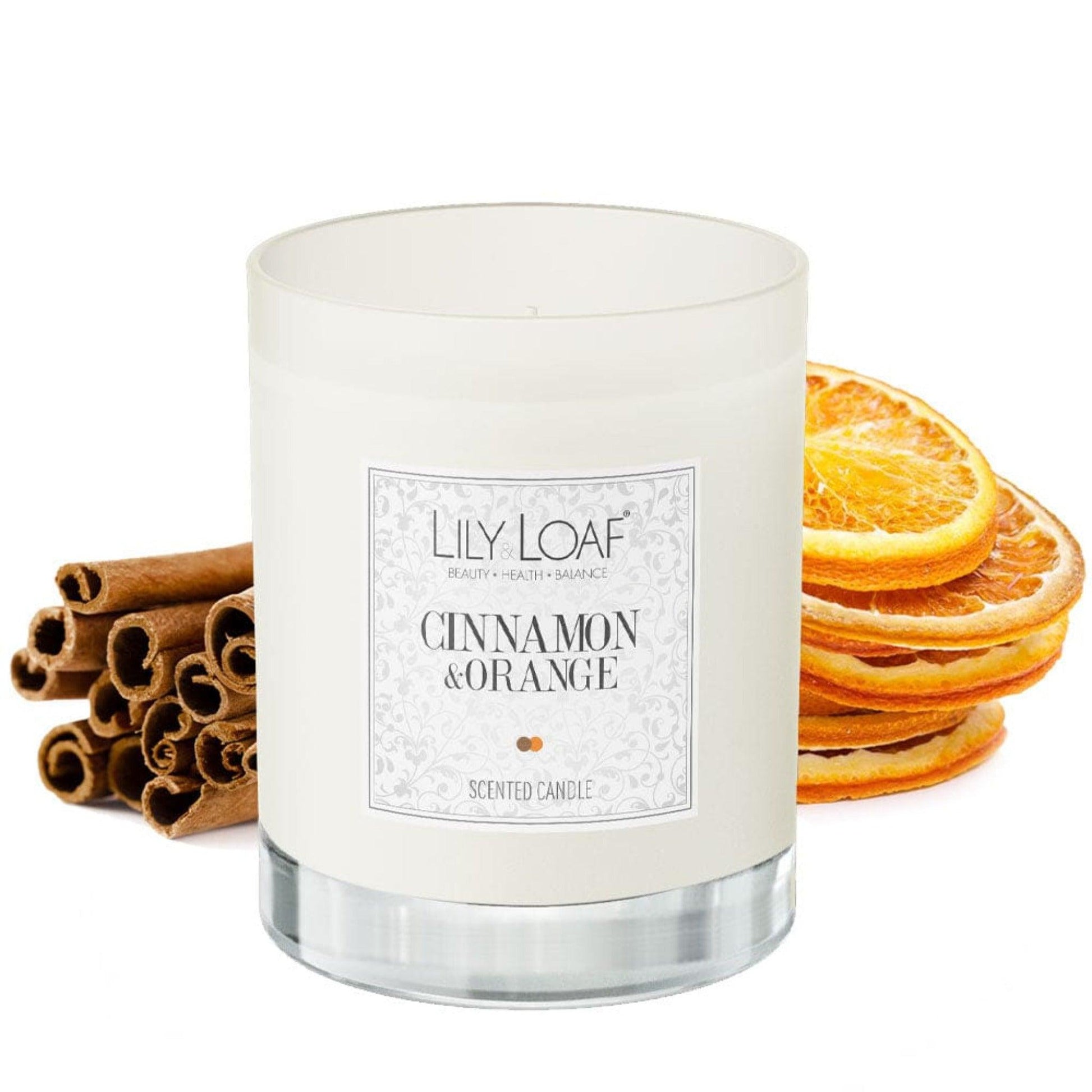 Lily & Loaf Cinnamon and Orange Soy Wax Candle surrounded by cinnamon sticks and orange slices depicting the botanical fragrance