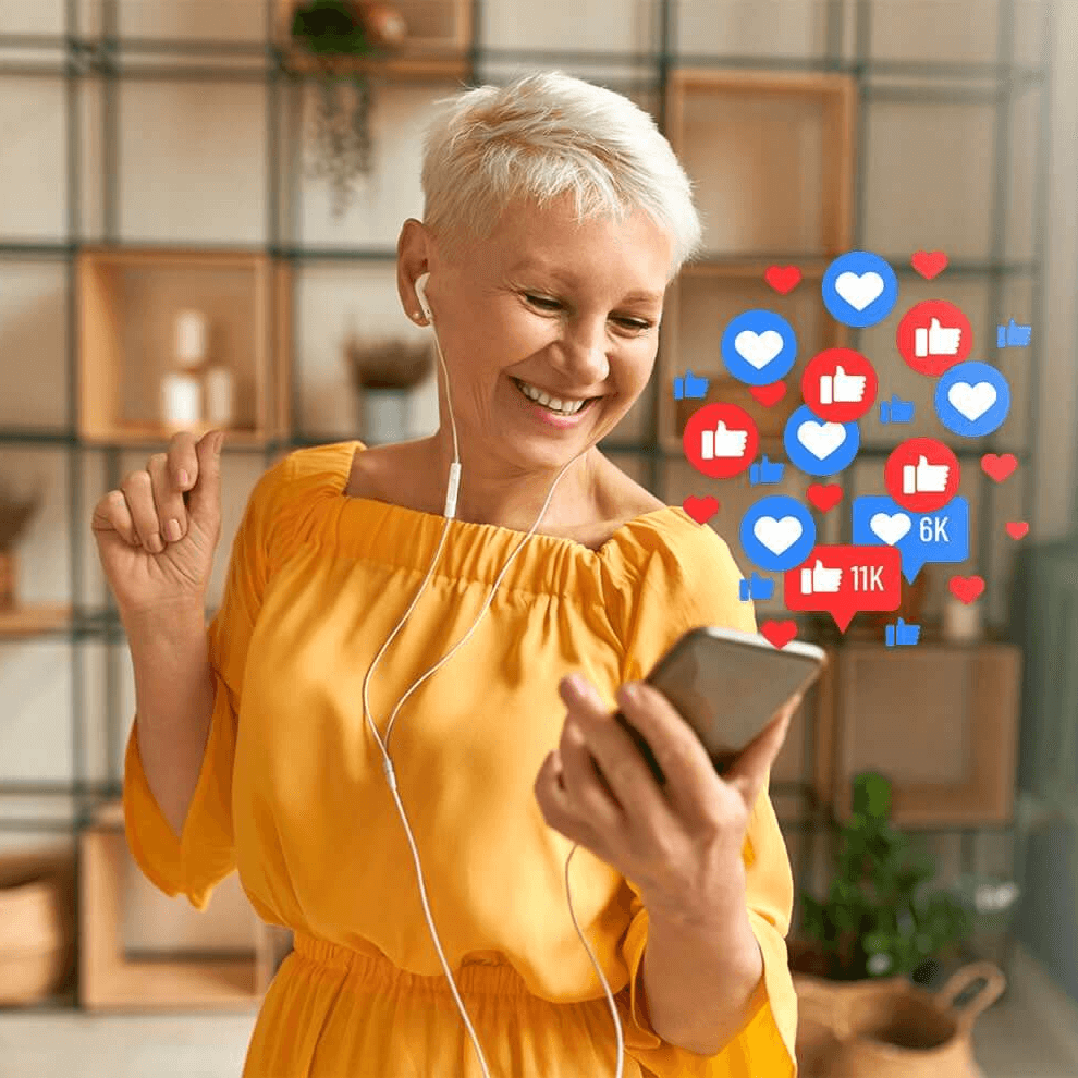 A woman smiling at her phone with social media heart and like icons 