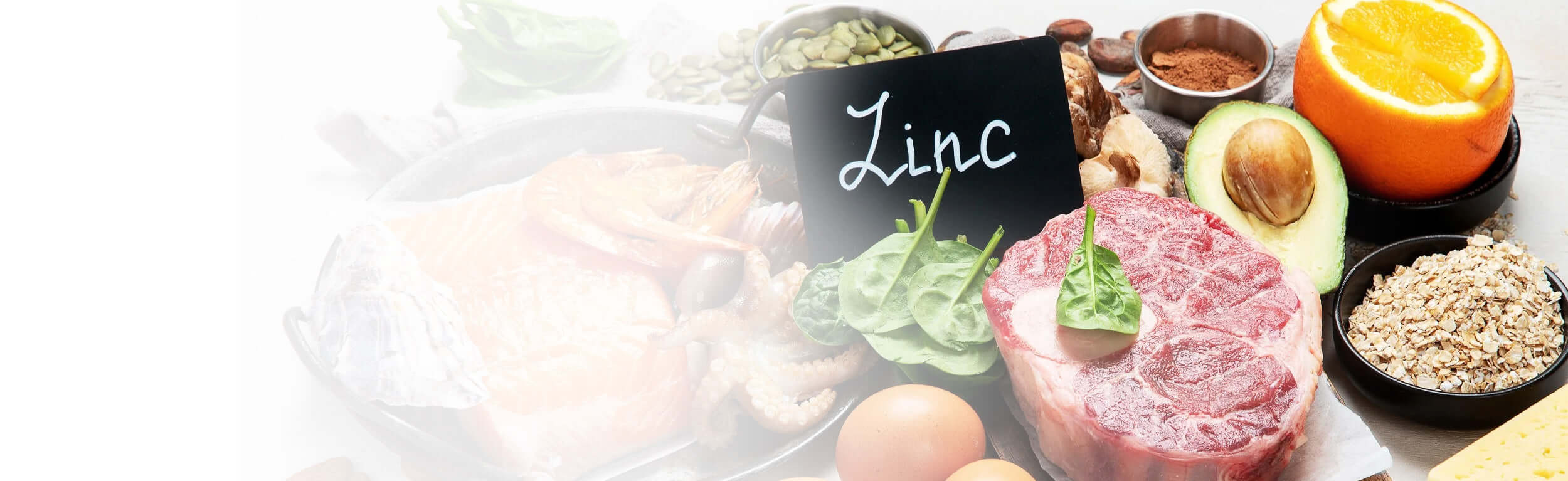 Mineral rich foods on a table and a chalkboard in the centre with the word Zinc written on