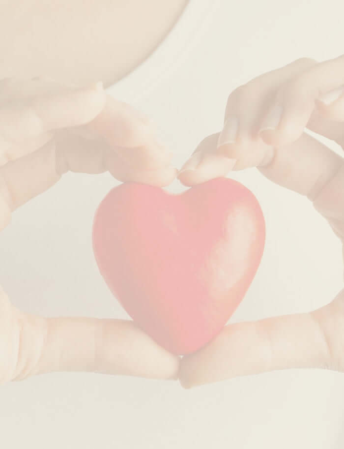 A close up of a person holding a red ceramic heart.