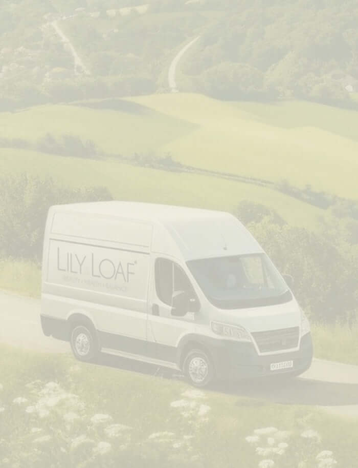 A white van with Lily & Loaf signage driving through the countryside