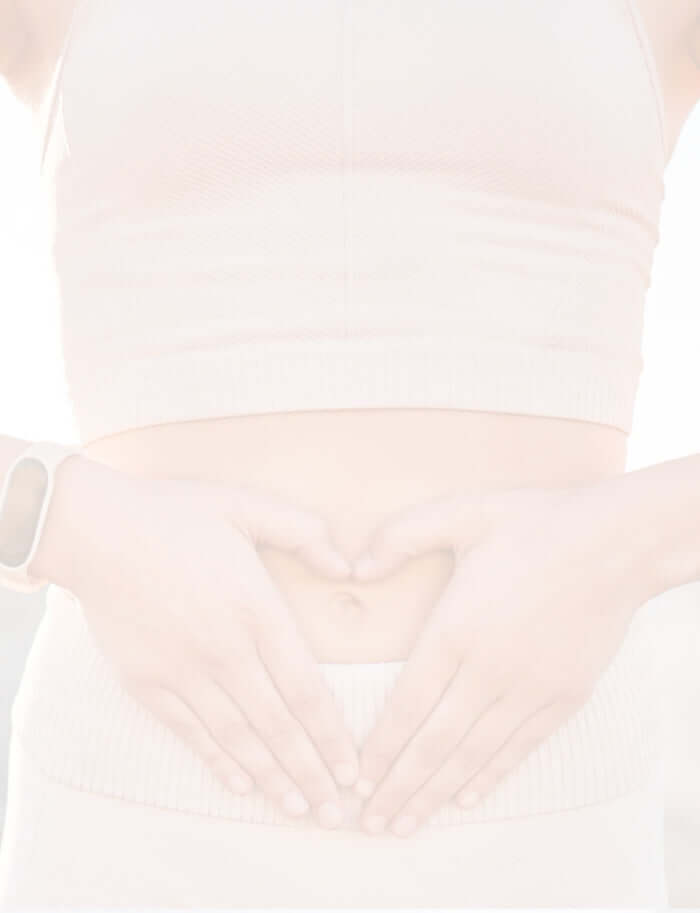 a lady with her hands creating heart against the tummy