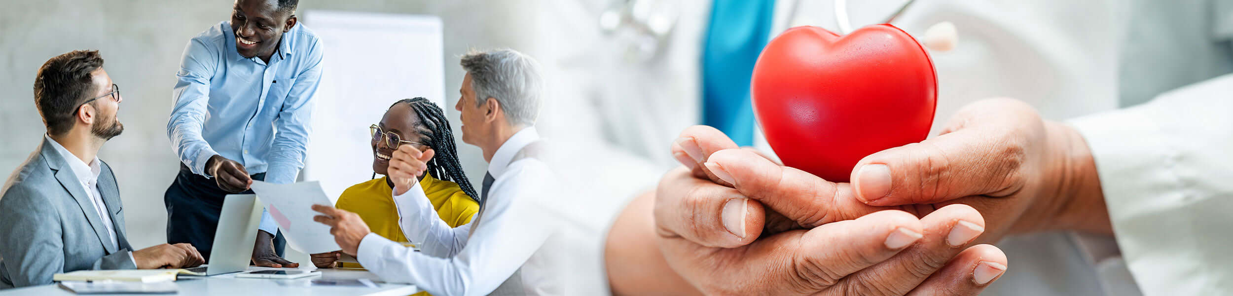 People in a meeting with a focus on a red heart held by hands, symbolizing health and care.