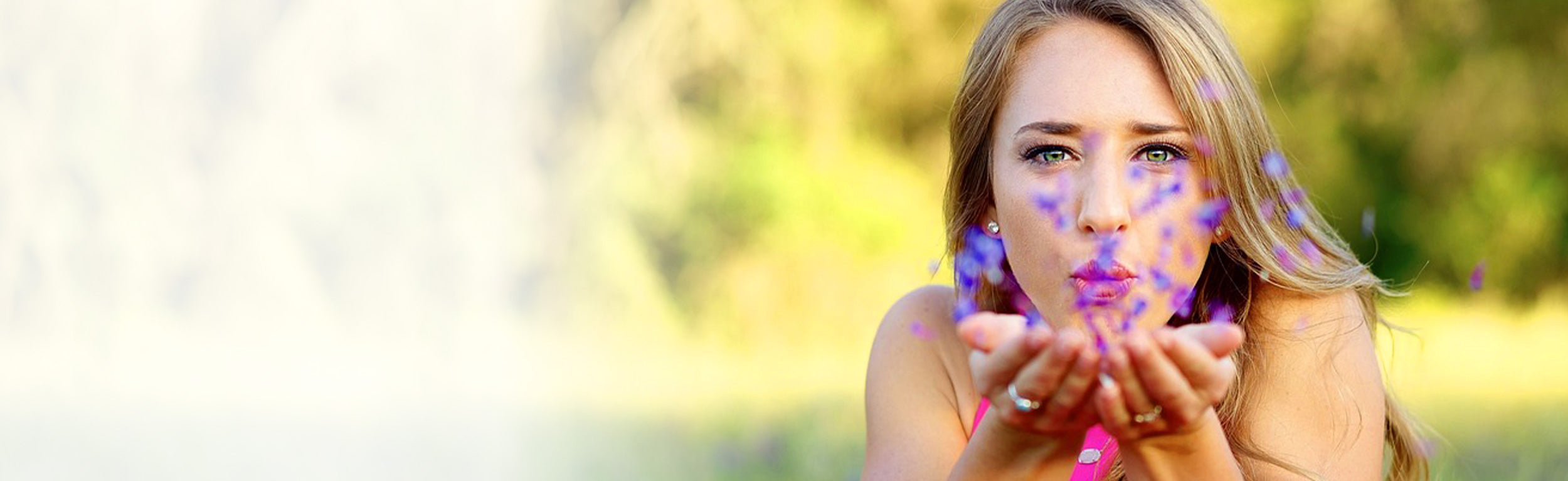 lady blowing flower petals towards you