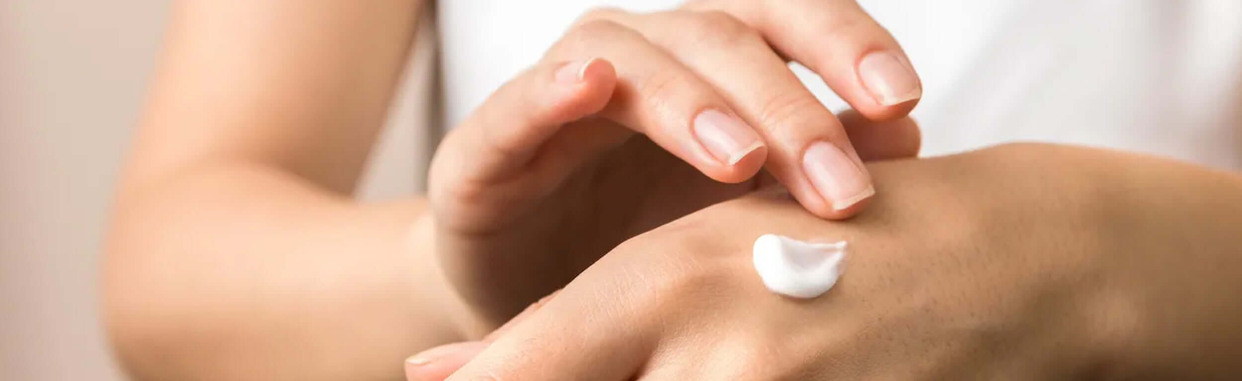 females hands massaging cream into the skin