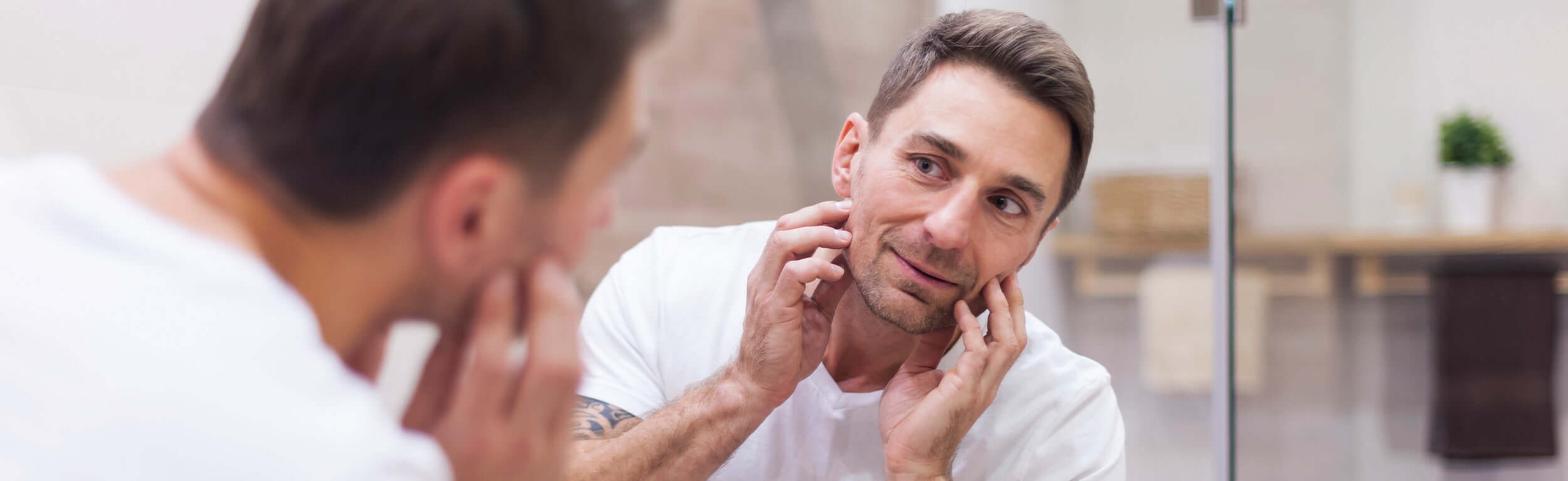 male skincare looking into mirror