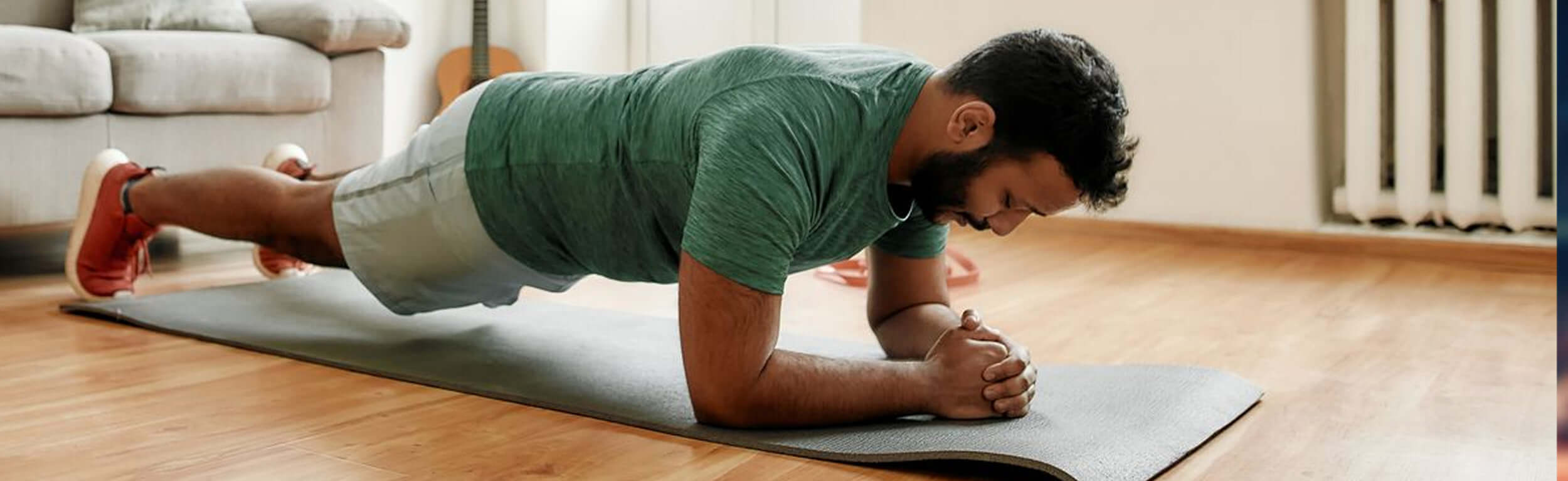 A male exercising at home doing the plank