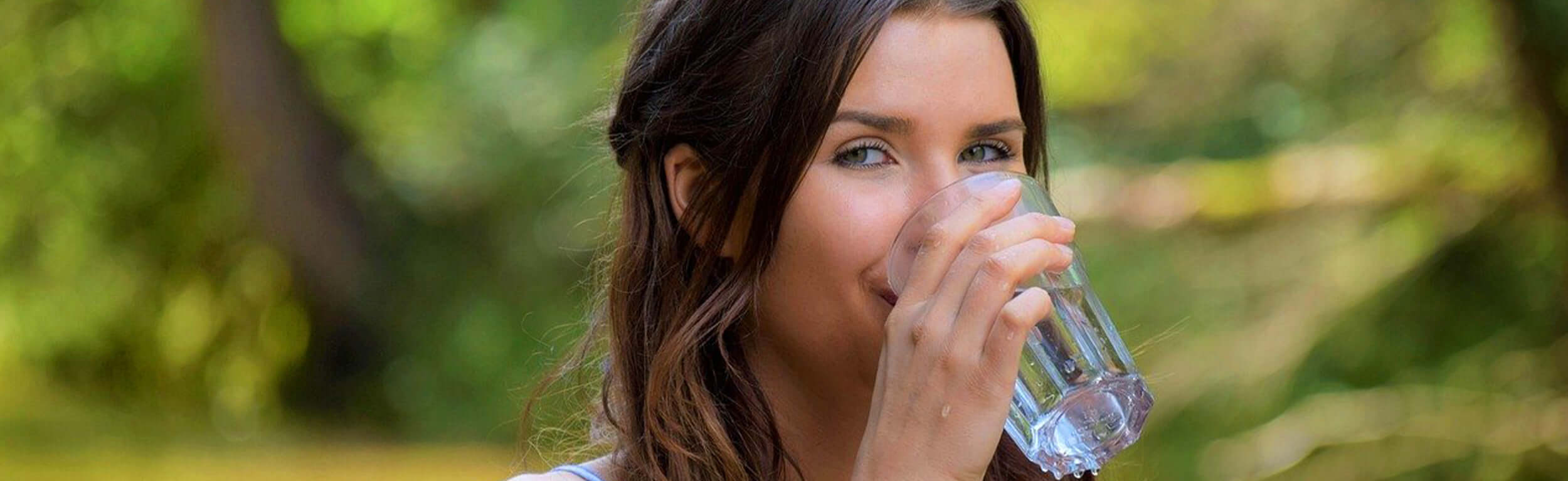 lady drinking glass of water in garden