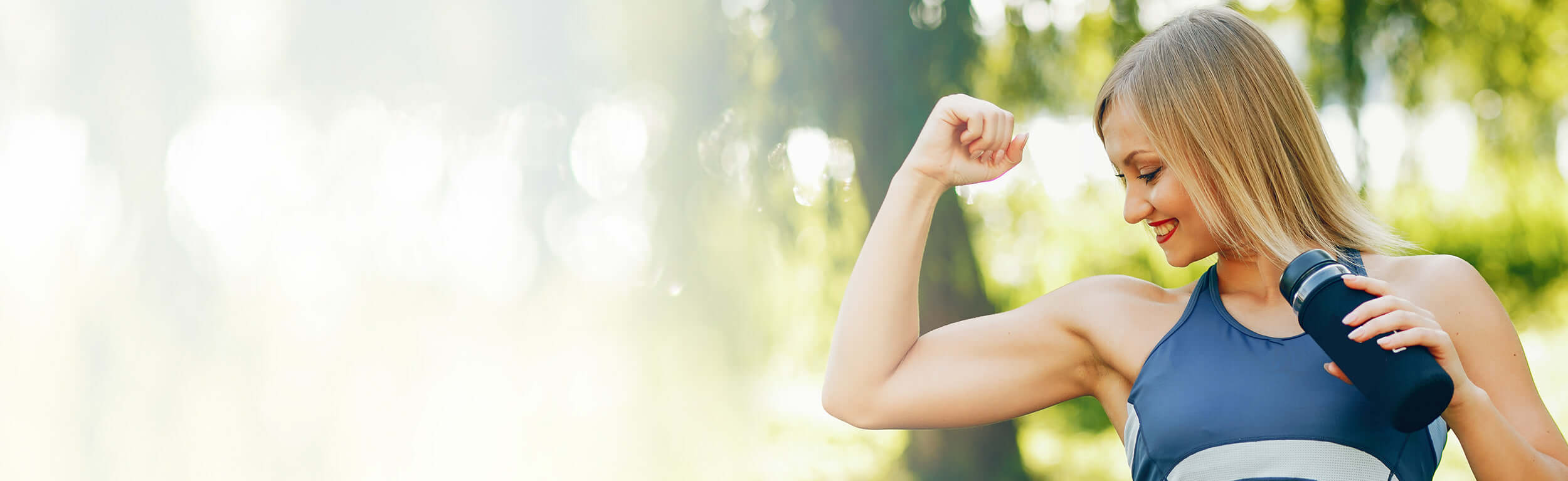 lady in park flexing arm muscles