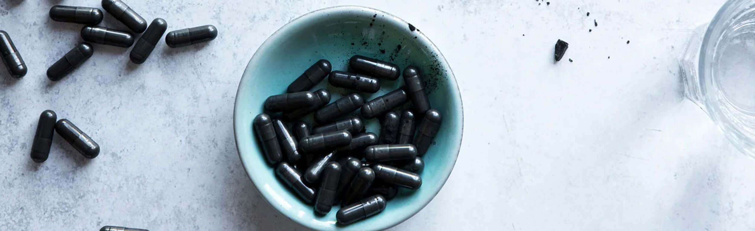 charcoal capsules in a blue bowl