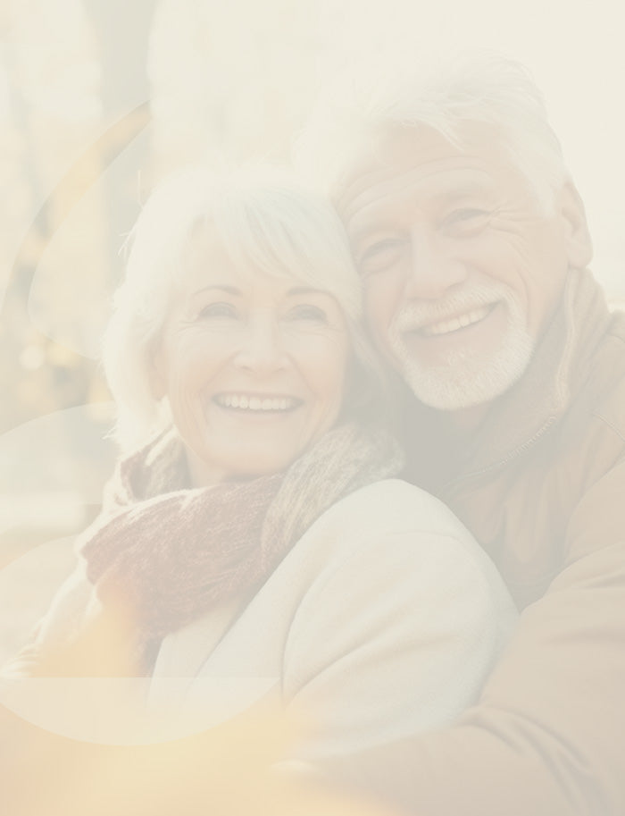 Two people sitting together, smiling, with a warm, soft focus effect.