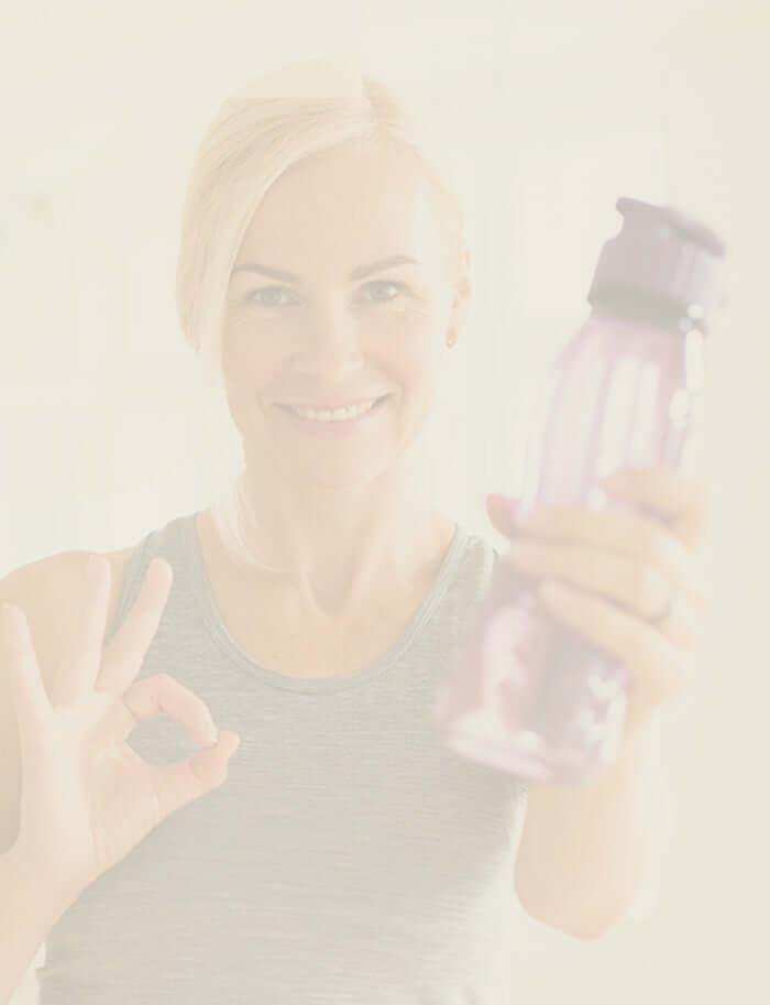 Woman holding a pink water bottle with a blurred background