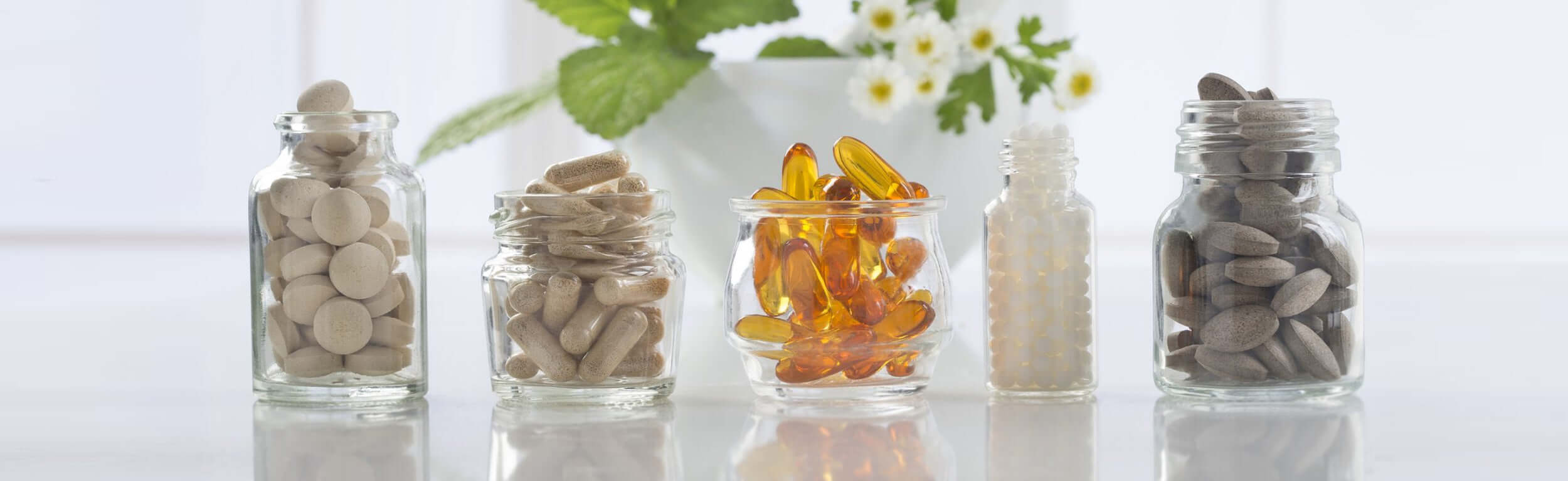 A variety of capsules and tablets in glass bottles