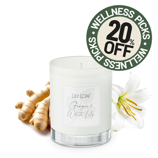 Ginger & White Lily Soy Wax Candle, styled with ginger roots and a white lily flower. A circular promotional badge reading '20% OFF WELLNESS PICKS' appears in the upper right.