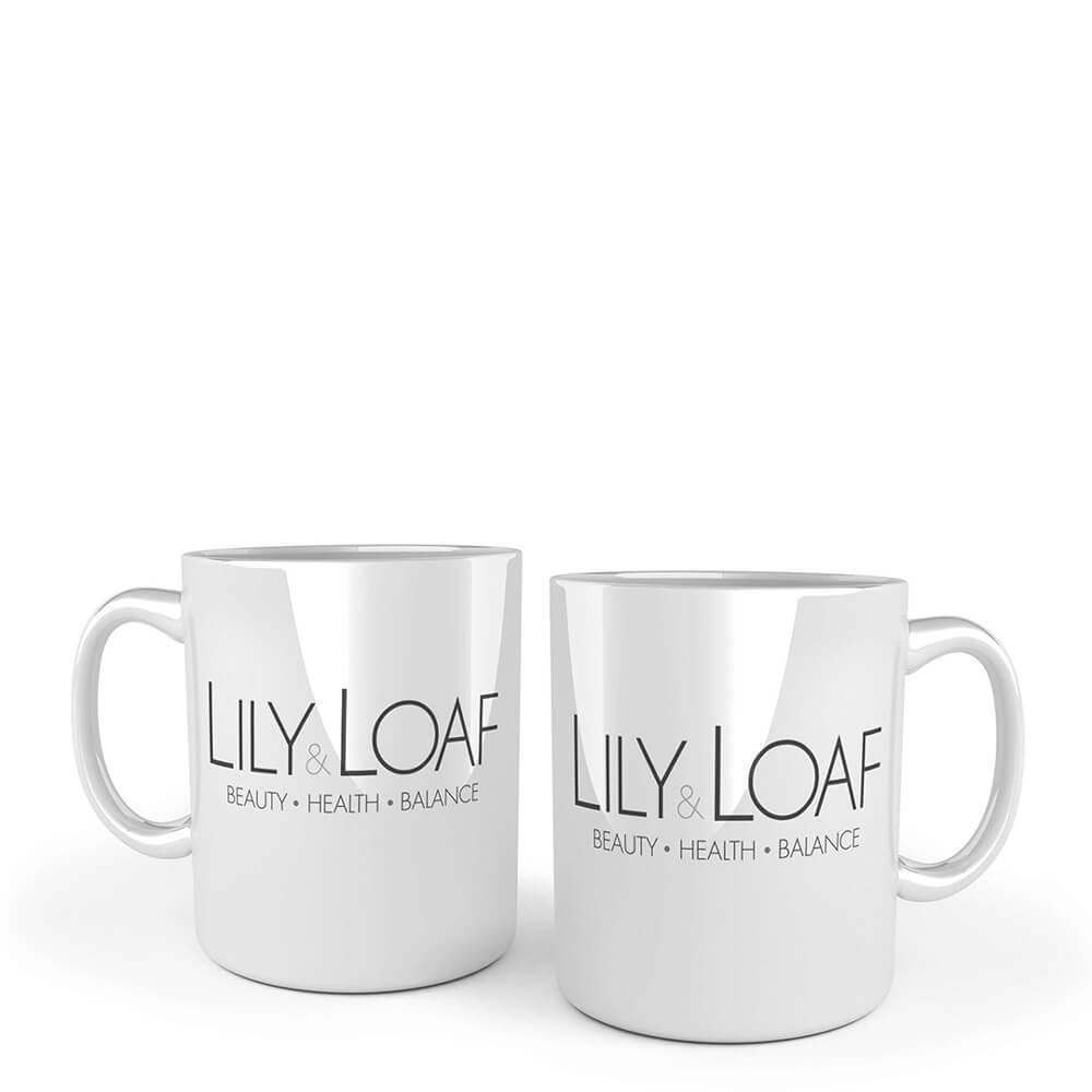 Two white ceramic mugs with the Lily & Loaf logo printed on the front and back.