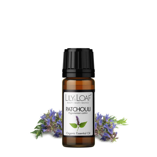 Patchouli Essential Oil bottle with fresh patchouli flowers