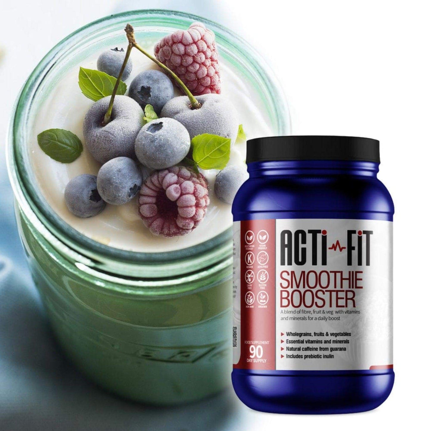 Acti-Fit Smoothie Booster tub beside a yellow smoothie topped with frozen blueberries, frozen raspberries and fresh mint.